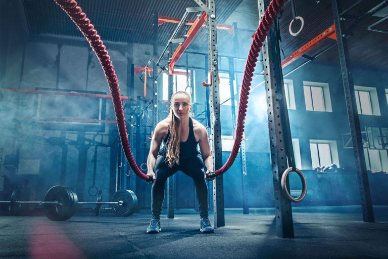 Frau beim Training mit Battle Ropes, Probetraining im Fitnessstudio Leinefelde buchen